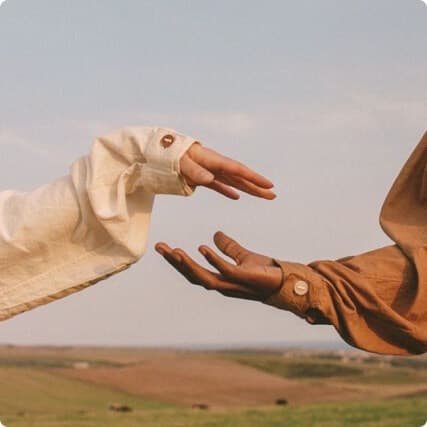 Символ доверия и близости: руки тянутся друг к другу.